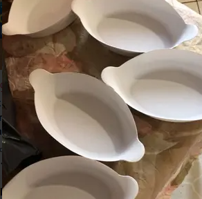 Quatro petisqueiras brancas organizadas sobre uma mesa